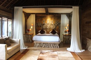 A bedroom with a bed, curtains, zebra wall art, and two bedside lamps. - Kropak Canggu (Kerobokan)