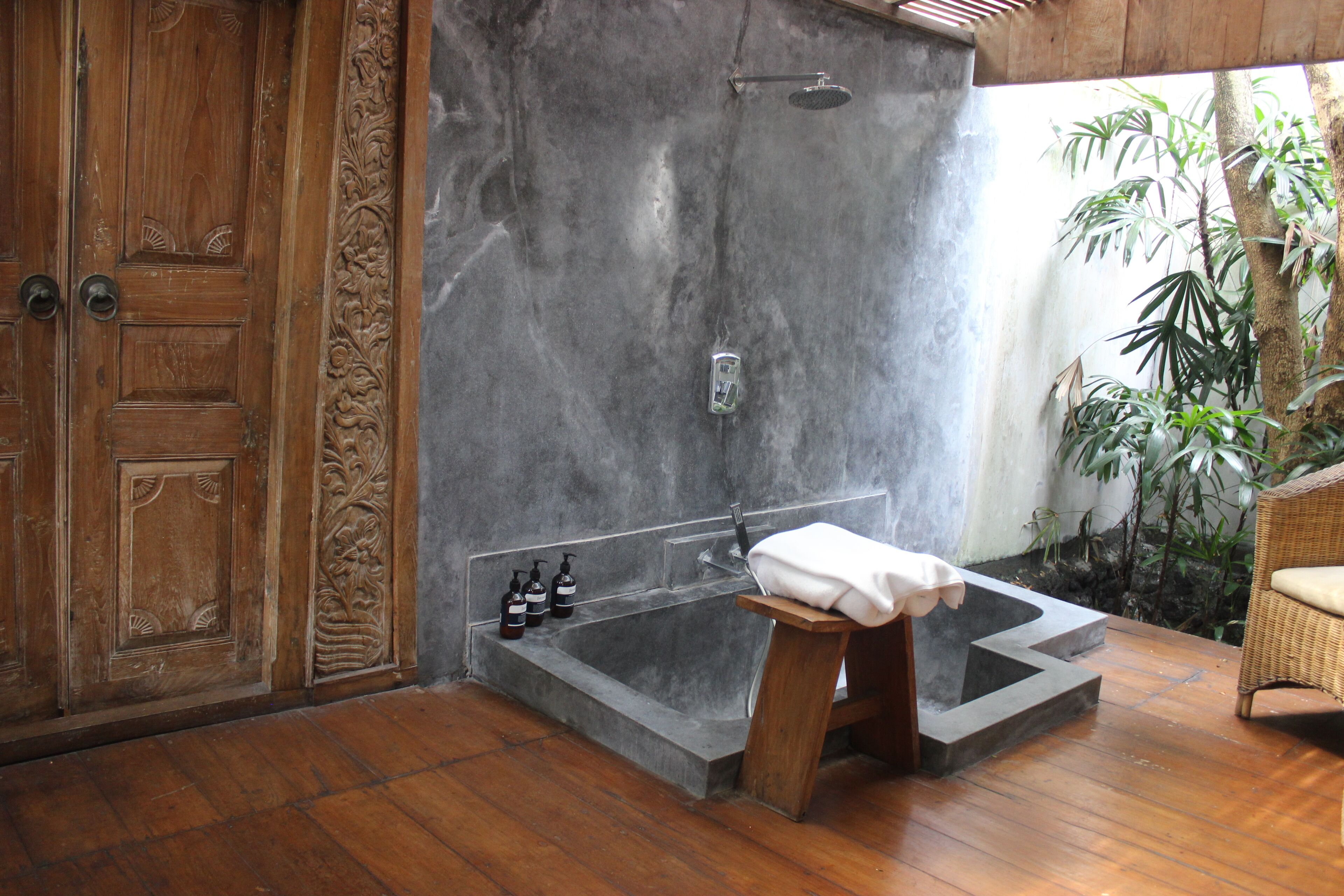 Un baño con una puerta de madera grande, una bañera y una zona de ducha.