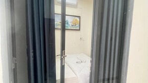 Ένα δωμάτιο με ένα κρεβάτι, έναν πίνακα στον τοίχο και μια μονάδα κλιματισμού.