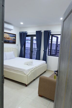 A hotel room with a bed, a window with curtains, a painting on the wall, and a balcony. - Motel Mys Dung as  Motel Lavie  (Tay Nha Trang)