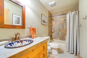 Un baño con lavamanos, inodoro y bañera.