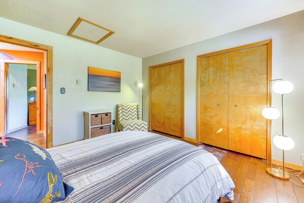 A bedroom with a bed, a wardrobe, a bedside table, a lamp, and a painting on the wall. - Durango Snow Days: Hot Tub & Fire Pit (Durango)