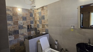 Un baño con piso de baldosas, inodoro, lavamanos y espejo.