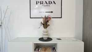 A white console table with a framed sign above it that reads "PRADA MARFA 1837 MI". - Aster apartment - Free Parking in the historic center of Alba - Langhe (Alba)