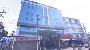 Ένα κτίριο με μια πινακίδα που αναγράφει «Brindavan Hotels» και «Δωμάτια με κλιματισμό, δωμάτια χωρίς κλιματισμό».