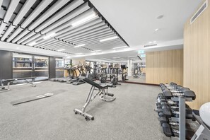 A gym with treadmills, elliptical machines, and weight stations.