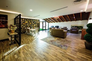 Suite ejecutiva, patio, vistas al patio | Zona de estar | Televisión de pantalla plana de 45 pulgadas con canales digitales