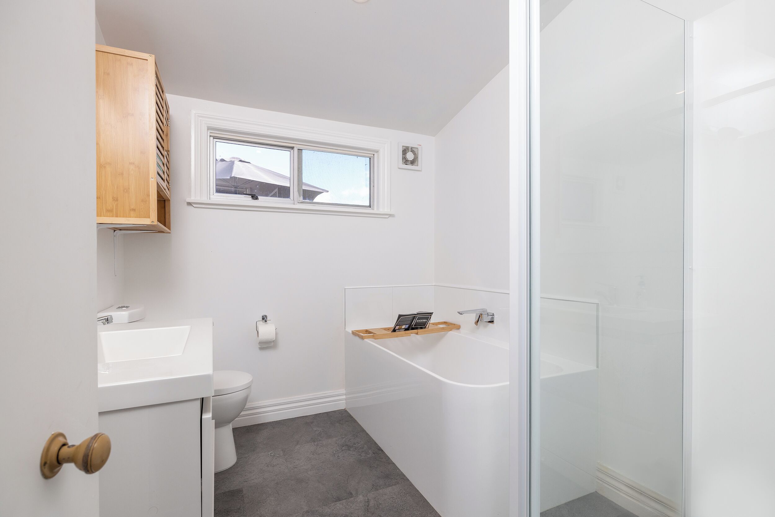 Ein modernes Badezimmer mit Toilette, Waschbecken und Duschkabine aus Glas.