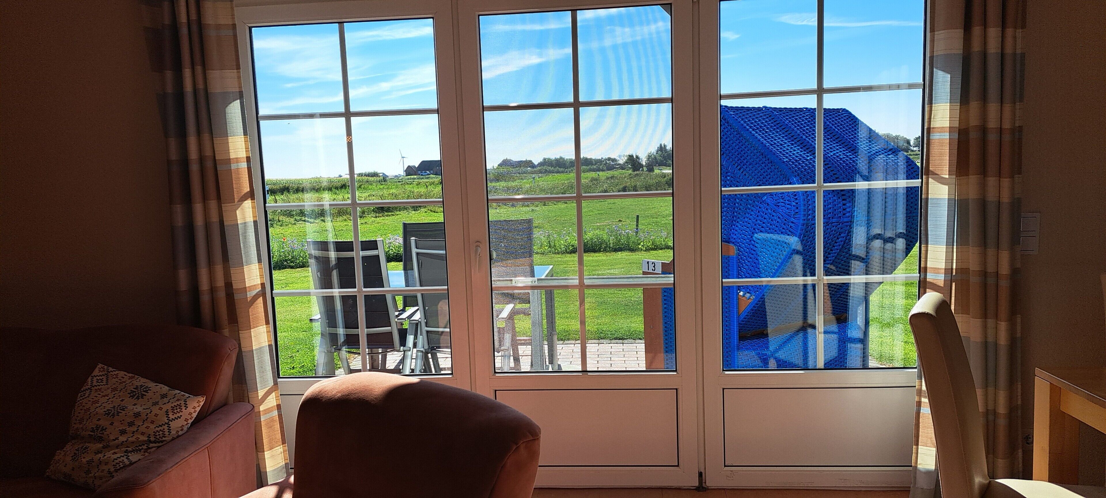 Ein Zimmer mit einer großen Schiebeglas-Tür, die zu einem Außenbereich mit Tisch und Stühlen führt.
