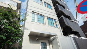 Un bâtiment moderne, avec une enseigne indiquant la présence d’un bureau de poste, une porte en métal et une porte d’entrée bien visible.