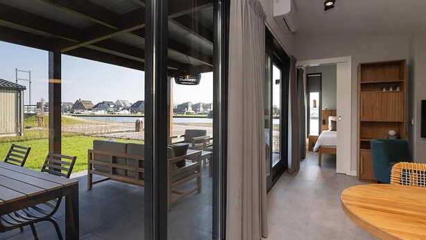 Ein modernes Hotelzimmer mit einer großen Glasschiebetür, die auf eine Terrasse im Freien führt.