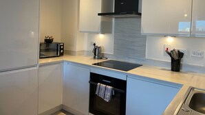 A modern kitchen with a built-in oven, a microwave, a kettle, and a sink. - 2 Bed with Wi‑Fi, Near Central Birmingham (Birmingham)