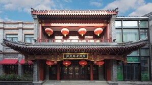 A traditional Chinese building with a red and gold facade, a balcony with red lanterns, and a sign in Chinese characters. - Yitingzhenshe Hotel Beijing Tiananmen (Beijing)