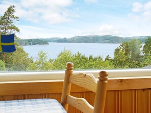 A wooden chair with a view of a lake and hills. - 5 Person Holiday Home in Munkedal (Munkedal)