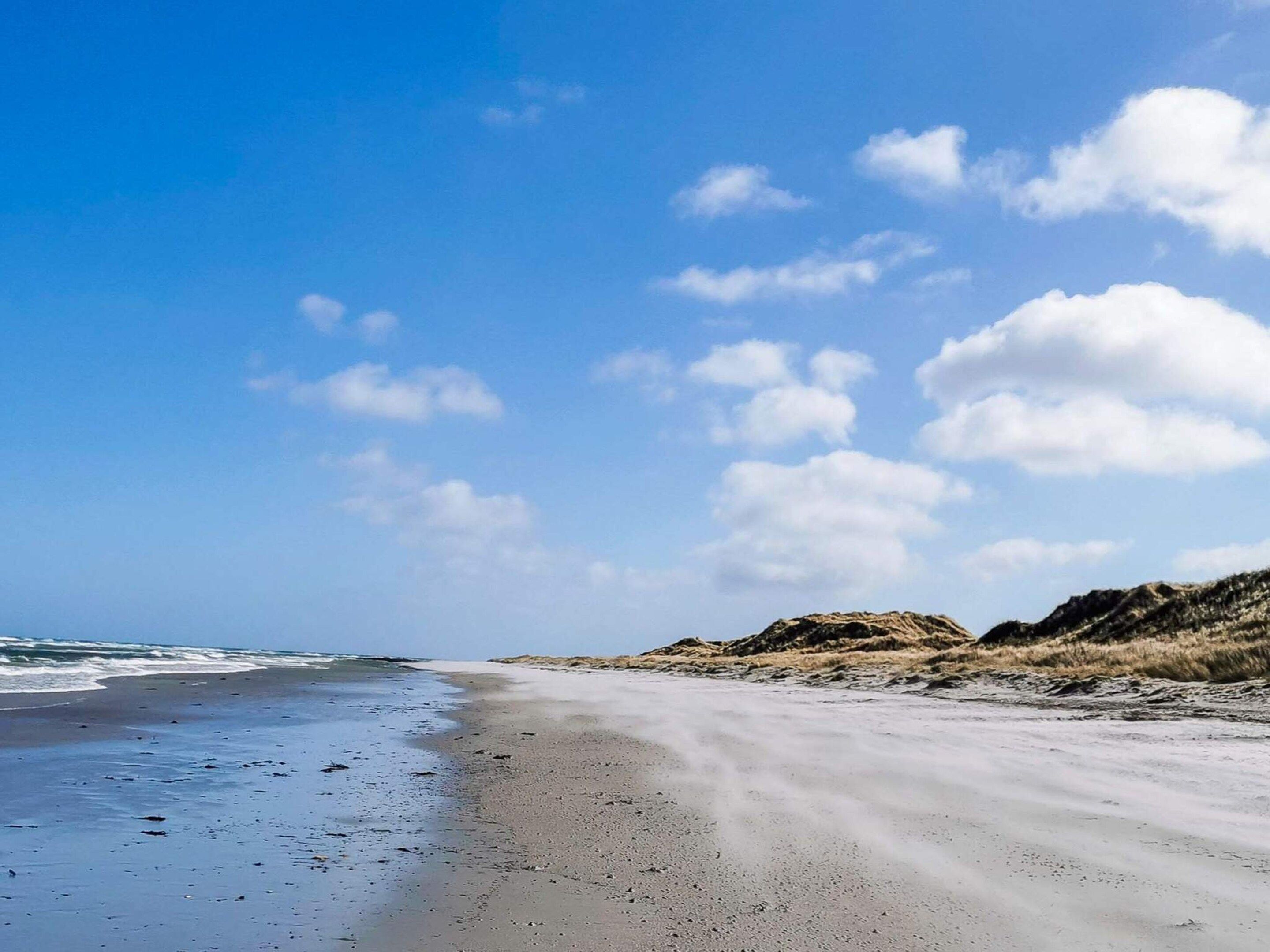 A beach with a clear sky and gentle waves.