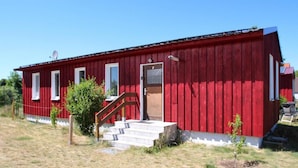 A red wooden building with a door, windows, and a satellite dish. - Ferienhaus am Vilzsee, Mirow (Mirow)