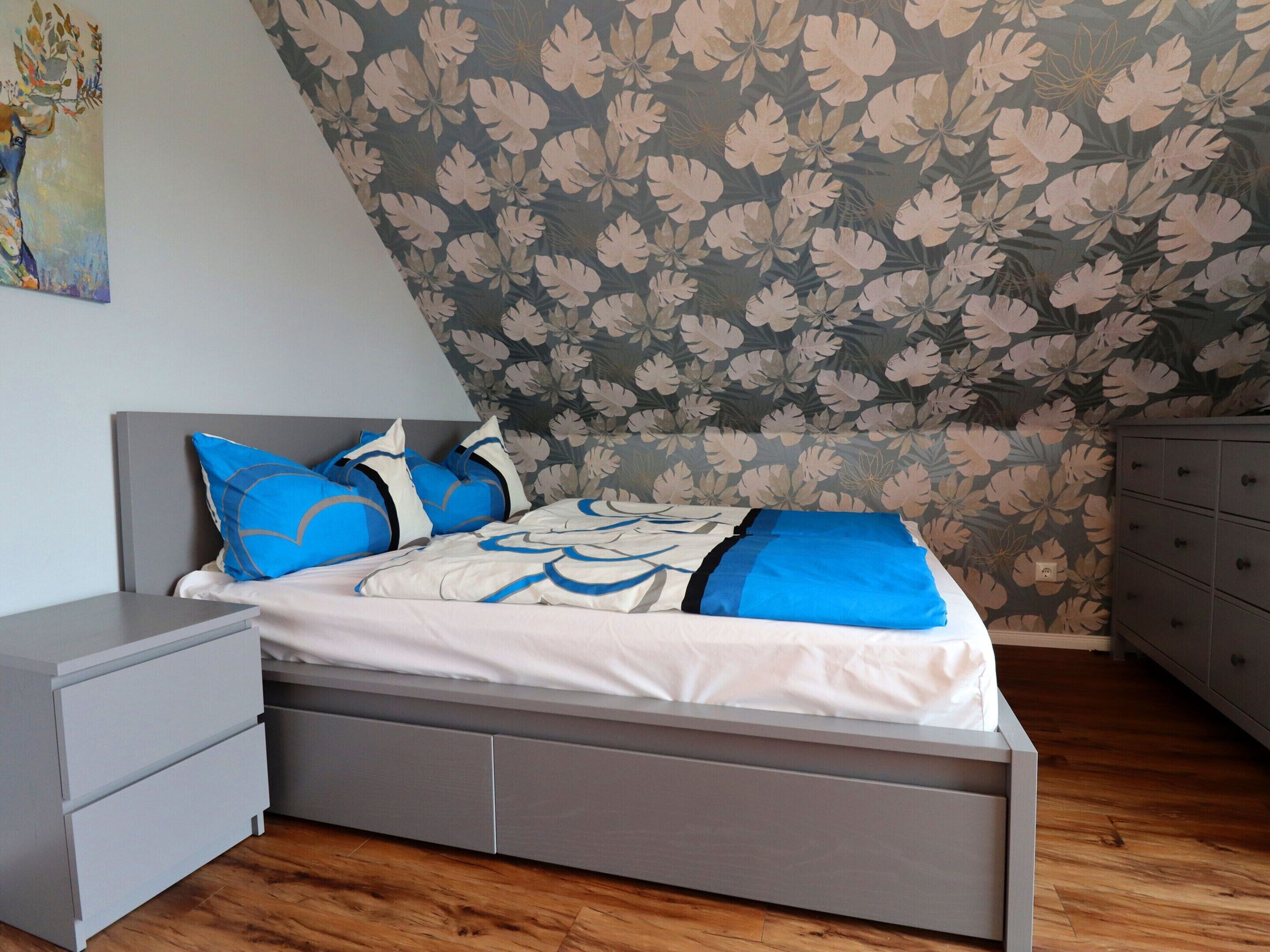 A bedroom with a bed, nightstands, and a dresser.