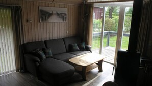 Ein Zimmer mit einem dunkelgrauen Sofa, einem Holztisch und einem Gemälde an der Wand.