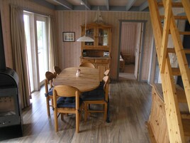Un comedor de madera con una mesa, sillas, una lámpara de araña y un aparador de madera.