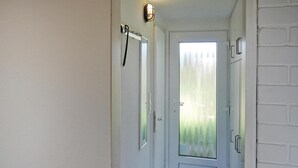 A narrow hallway with a frosted glass door, a white door on the right, and a small rug on the floor. - Holiday Home in Burhave Near the sea (Butjadingen)