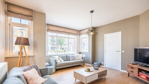 Een moderne woonkamer met een bank, salontafel en tv-meubel.