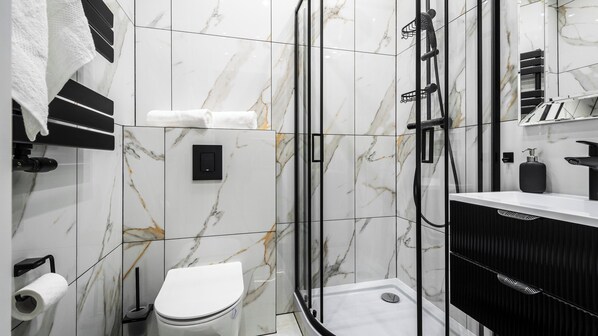 Une salle de bain moderne équipée d’une douche, de toilettes et d’un lavabo.