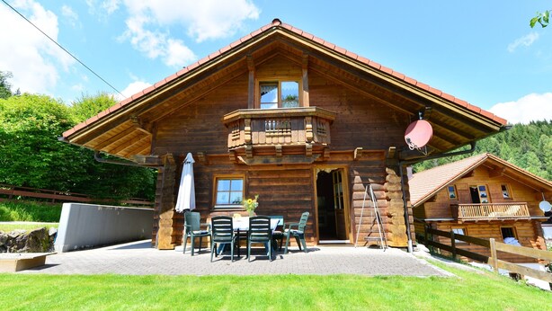 A wooden chalet with a balcony, outdoor seating, and a mountain view. - Ferienhaus aus Holz in der Nahe des Skigebiets (Bayerisch Eisenstein)
