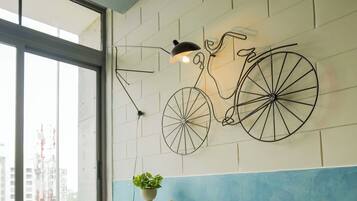 A modern interior with a sofa, a table, and a wall-mounted bicycle artwork.