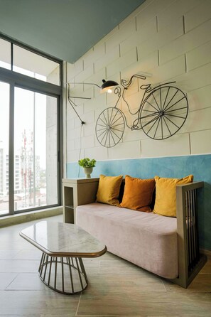 A modern interior with a sofa, a table, and a wall-mounted bicycle artwork.