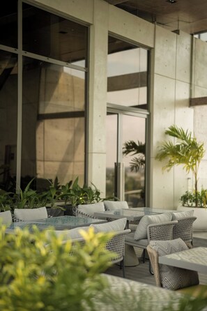 An outdoor seating area with wicker furniture and potted plants.