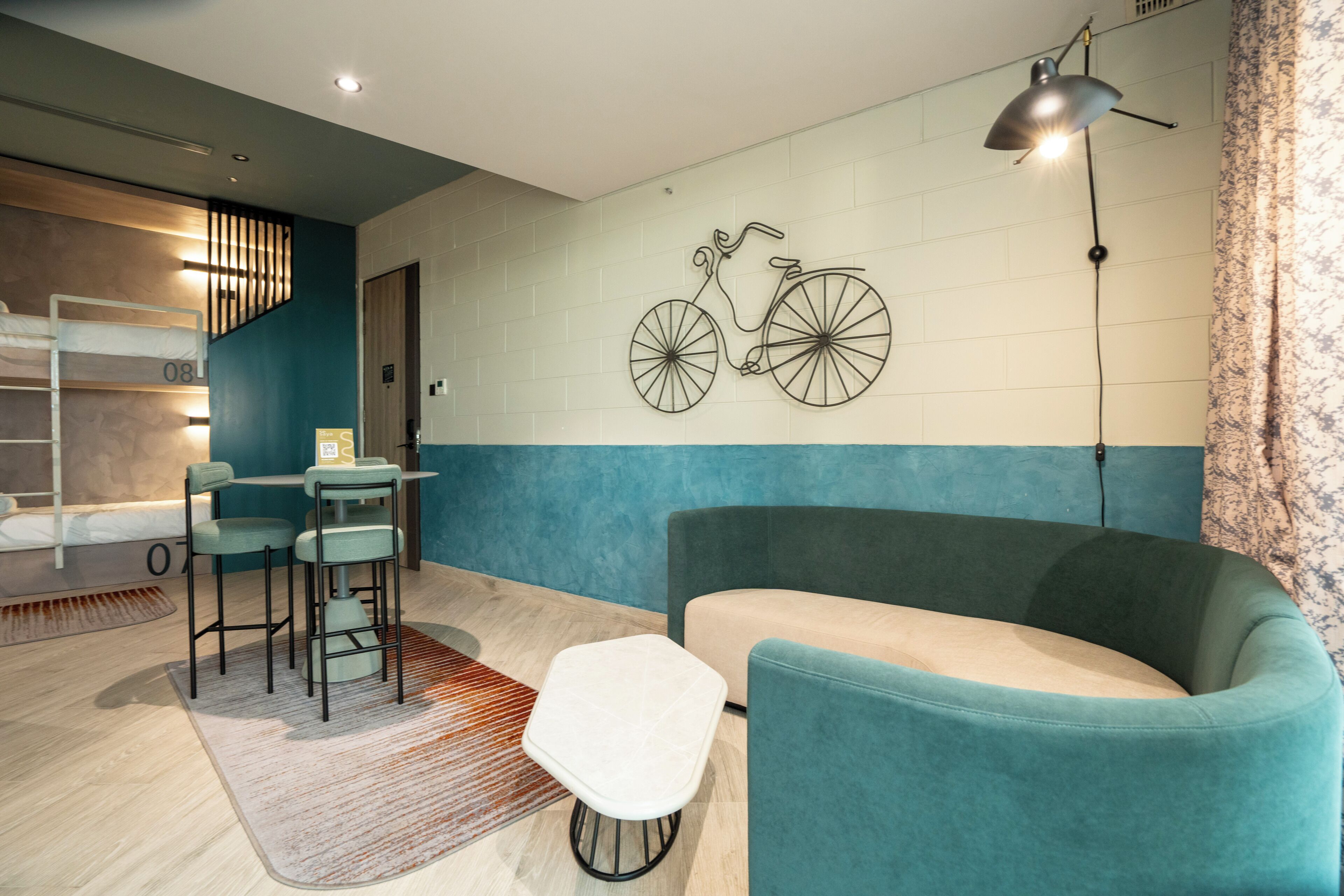 Ein modernes Wohnzimmer mit einer Couch, einem Esstisch mit Stühlen, einer Wanddekoration mit einem Fahrrad und einer Treppe.
