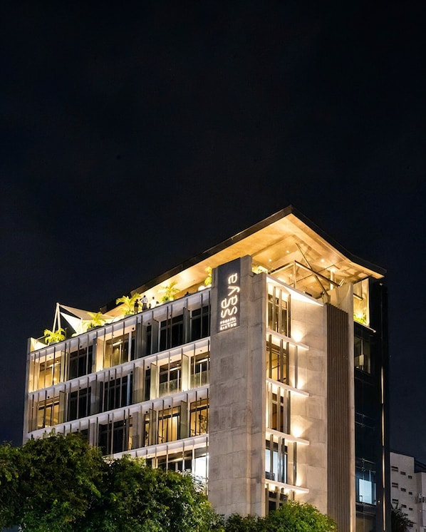 A modern building with a flat roof, large windows, and a prominent vertical sign. - SeSaya Poshtel & Bistro - Colombo's Newest and Finest Poshtel Dorms and Rooms (Sri Jayawardenepura Kotte)