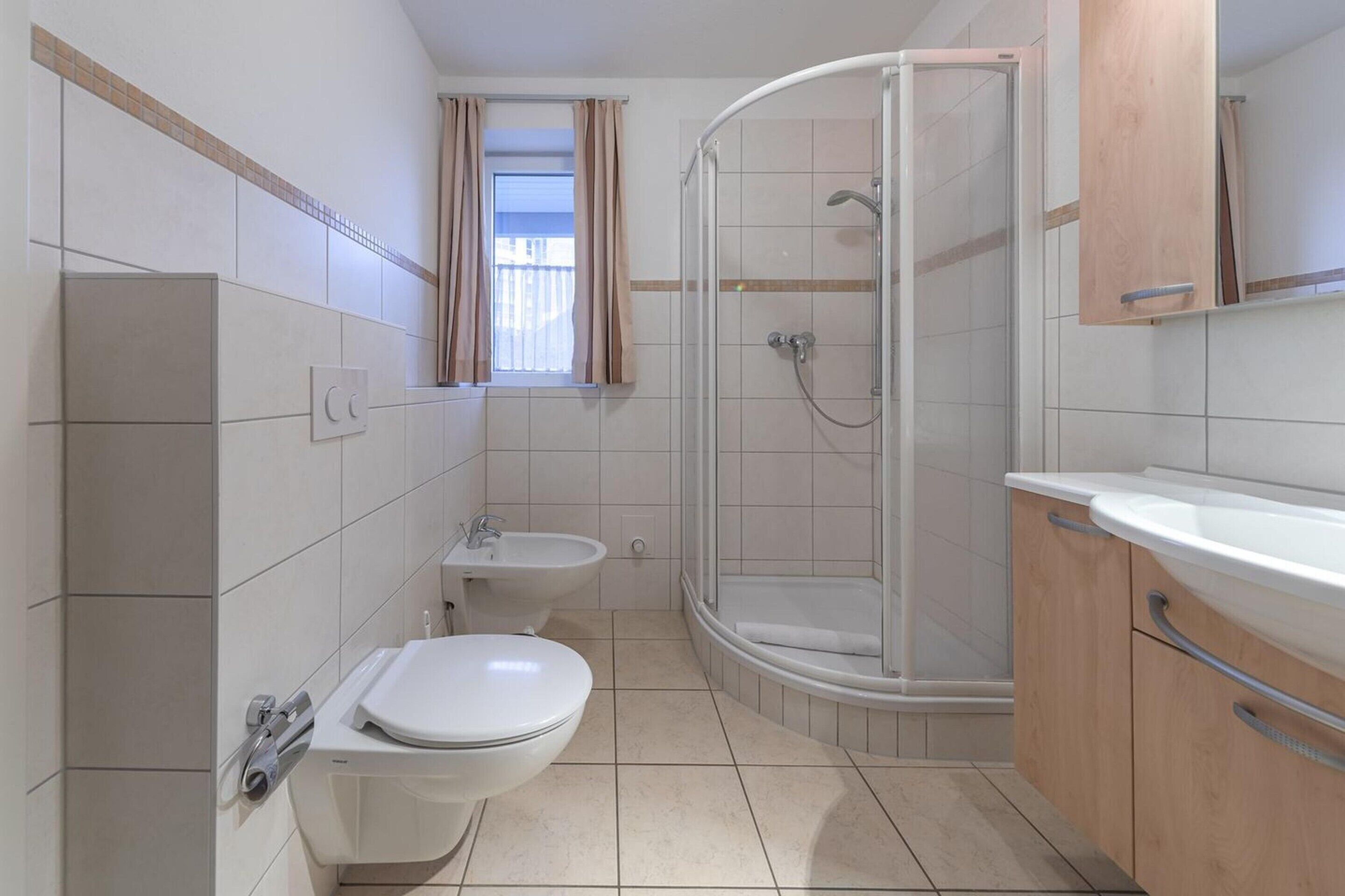 Un baño con inodoro, bidé y ducha.