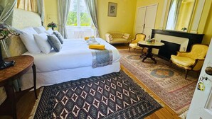 Una habitación con cama, escritorio, silla, mesa, espejo y armario.