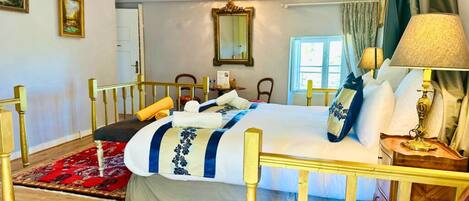 A hotel room with a bed, a nightstand, a lamp, a mirror, and a window.