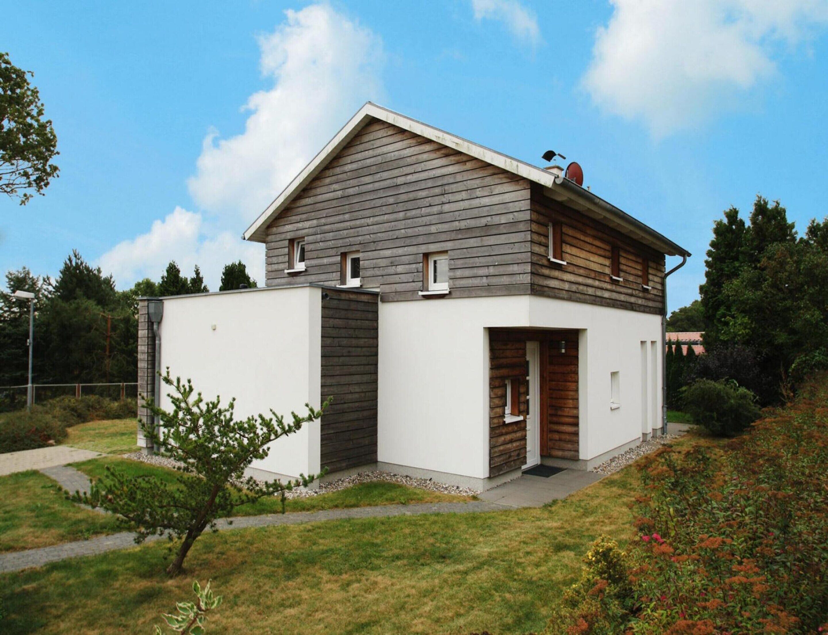 A modern two-story house with a sloped roof, a small porch, and a garage.