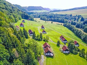 An aerial view of a rural area with several houses with red roofs, surrounded by green fields and trees. - Stunning private villa for 8 guests with WIFI, pool, TV, patio, pets allowed and panoramic view (Nové Město Nad Metují)