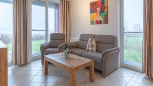 Ein Wohnzimmer mit einer Couch, einem Holztisch und einem Gemälde an der Wand.