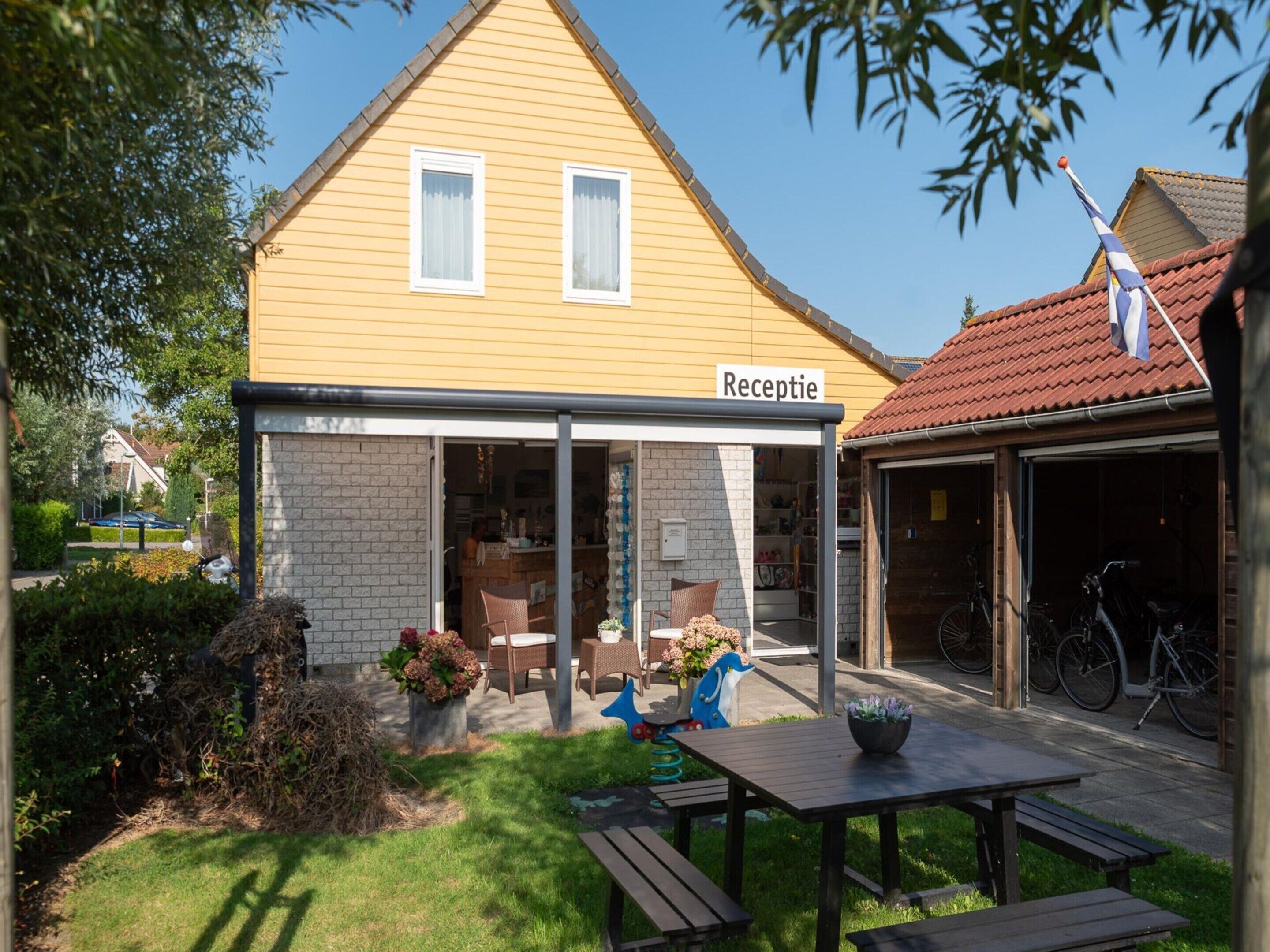 A yellow building with a sign reading "Rezeption" indicating a reception area.