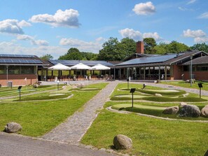 Enjoy a peaceful retreat in our serene outdoor space, featuring a paved pathway, comfortable seating area, and lush surroundings.