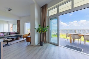 Una sala de estar moderna con un sofá, una mesa de centro y un comedor con sillas y una mesa.