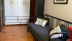 Een kamer met een bed, een garderobe en een schilderij aan de muur.