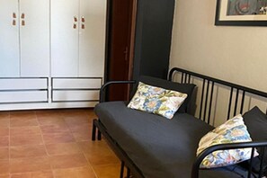 A small room with a bed, a wardrobe, and a framed picture on the wall. - Beautiful Villa in Playa Blanca (Lanzarote)