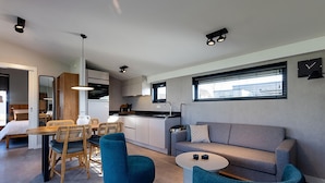 Um espaço de estar moderno com cozinha, área de refeições e zona de estar.