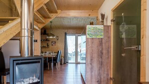 A wooden interior with a fireplace, dining area, and a wooden door with a map. - Appealing Chalet With hot tub (Sankt Georgen am Kreischberg)
