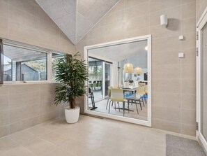 A modern bathroom with a large mirror, a potted plant, and a shower area. - 5 Star Holiday Home in Otterup (Otterup)