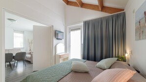 A bedroom with a bed, a desk, a chair, and a window. - Holiday Home in Zeeland With Garden Terrace (Wemeldinge)