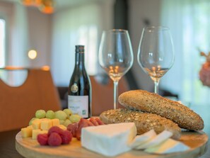 A charcuterie board with cheese, grapes, and meats, accompanied by a bottle of Merlot wine and two glasses. - Bungalow in Sondel Near Slotermeer Lake (Sondel)