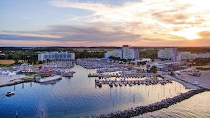 A marina with boats docked, surrounded by buildings and a sunset in the background. - Ferienhaus im Ostseebad Damp (Damp)