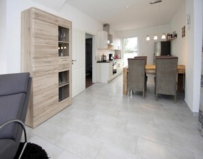 Enjoy meals in the kitchen with oven and dining area featuring a wooden table and chairs.